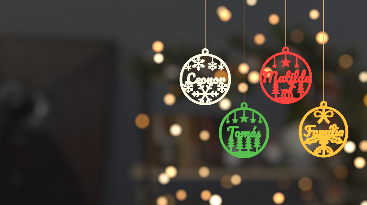 Bolas de Natal com nome penduradas, com luzes de Natal ao fundo